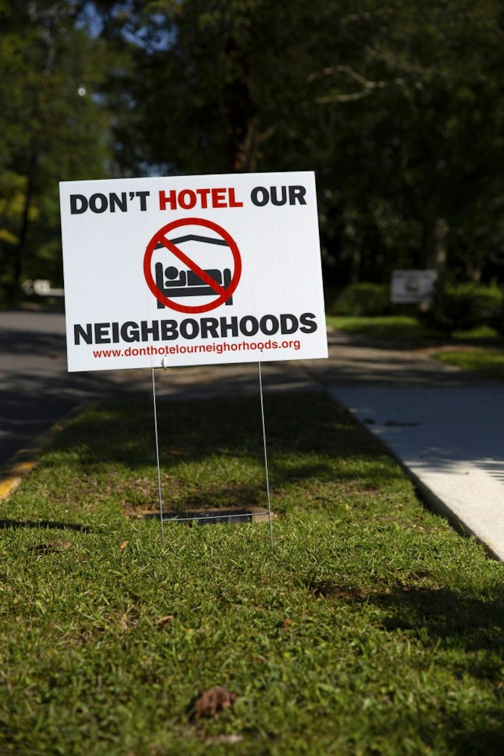Auburn residents post signs in their yards to speak out against short term rental properties.