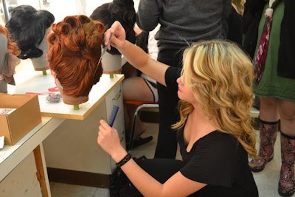 Alison Hora, freshman in theatre, prepares the wigs for the show. (Raye May / ASSOCIATE INTRIGUE EDITOR)