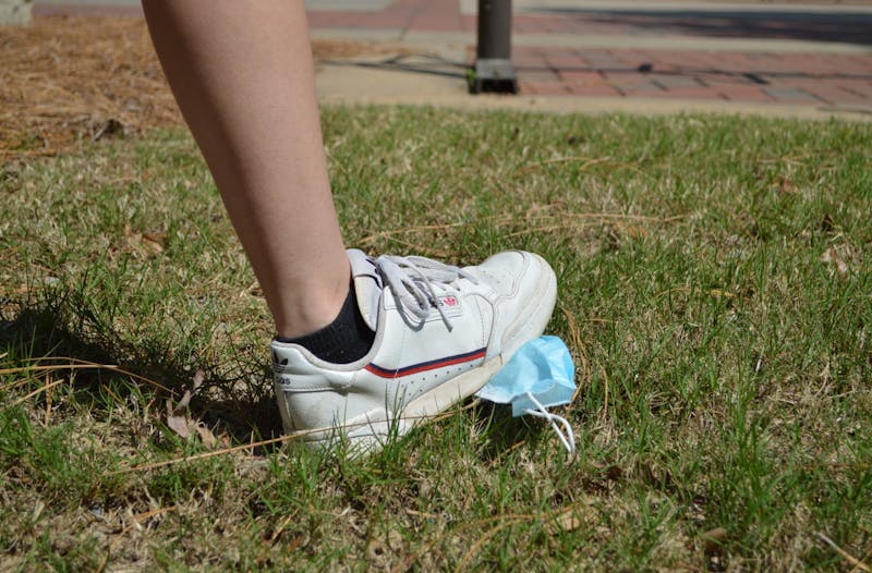 Auburn University student steps on a mask on Auburn Universities campus on Apr. 7, 2021, in Auburn, Ala.