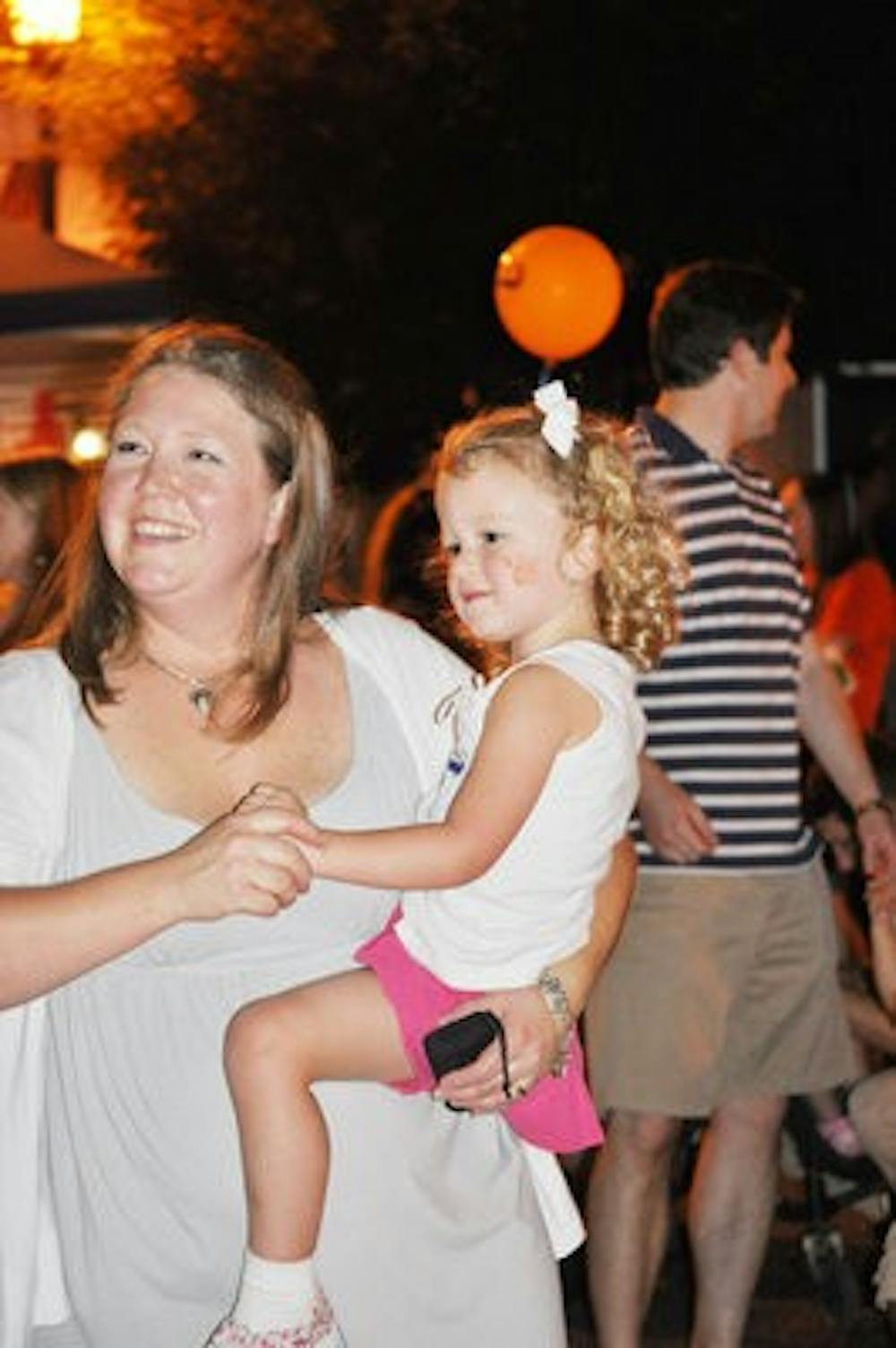 Ashley Sanders dances with her 4-year-old daughter Reese at the downtown block party Friday. (Katie Wittnebel / Photo Staff)