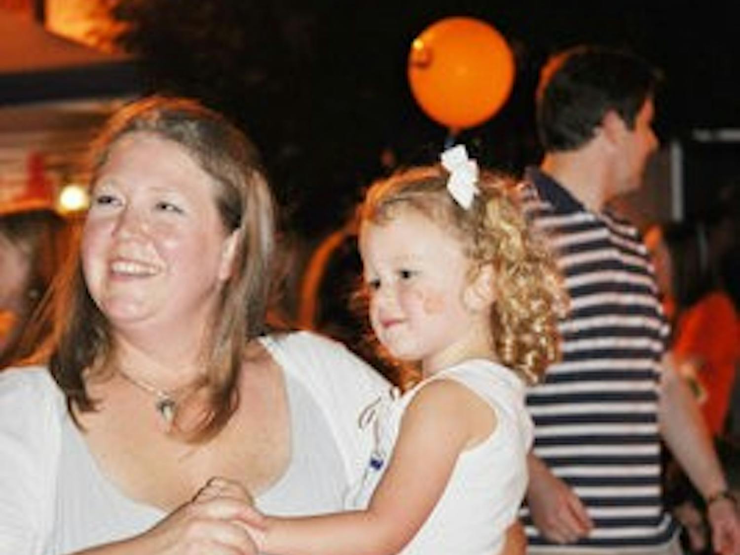 Ashley Sanders dances with her 4-year-old daughter Reese at the downtown block party Friday. (Katie Wittnebel / Photo Staff)
