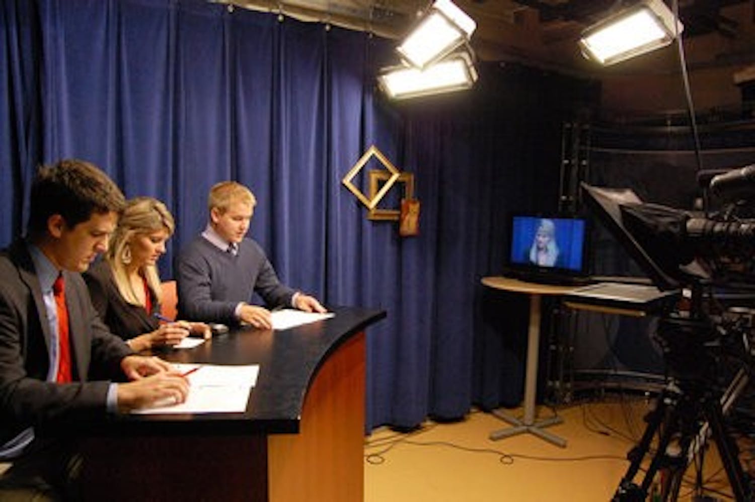 Matt Lally and Heather Galante, seniors in RTVF, and Danny O'Donnell, junior in RTVF, prepare for an upcoming newscast Monday. Eagle Eye TV broadcasts live three times a week. (Charlie Timberlake / ASSISTANT PHOTO EDITOR)