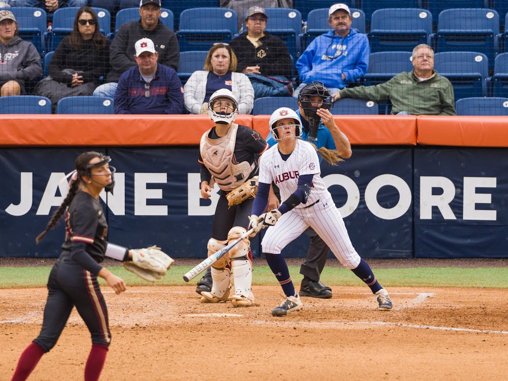 <p>Malayna Tamborra and the Coastal Alabama battery watch as a batted ball heads out over the wall in left-center field for a home run</p>