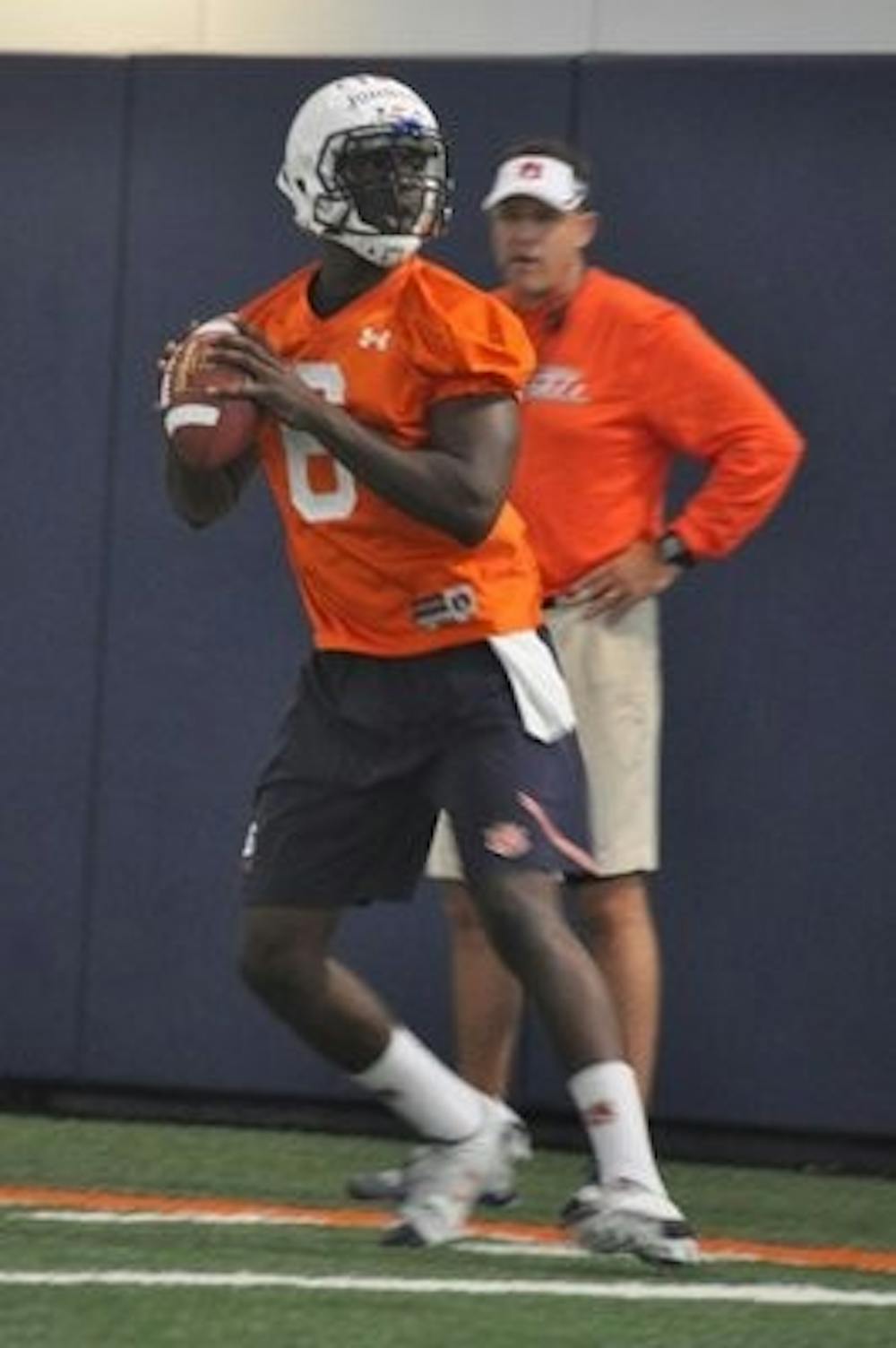 Gus Malzahn looks on as quarterback Jeremy Johnson goes through footwork drills.