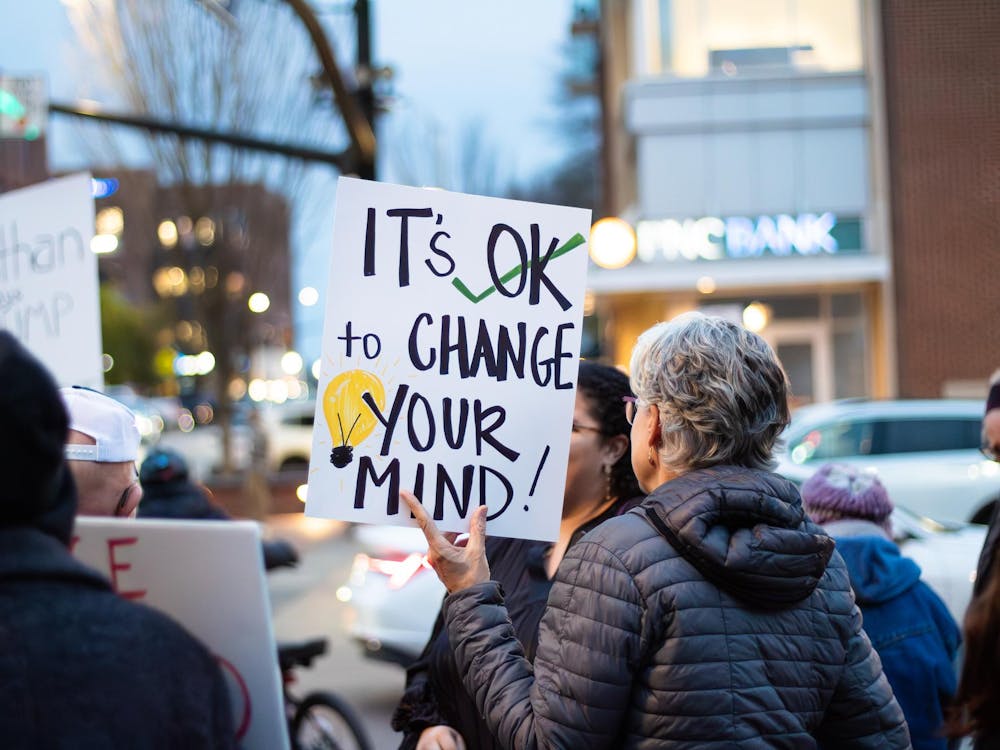 A protestor at the ICE, Immigration and Customs Enforcement, protest on Jan. 21, 2026 at Toomer's Corner in Auburn, Ala. holds a sign that says 'It's OK to change your mind!'.