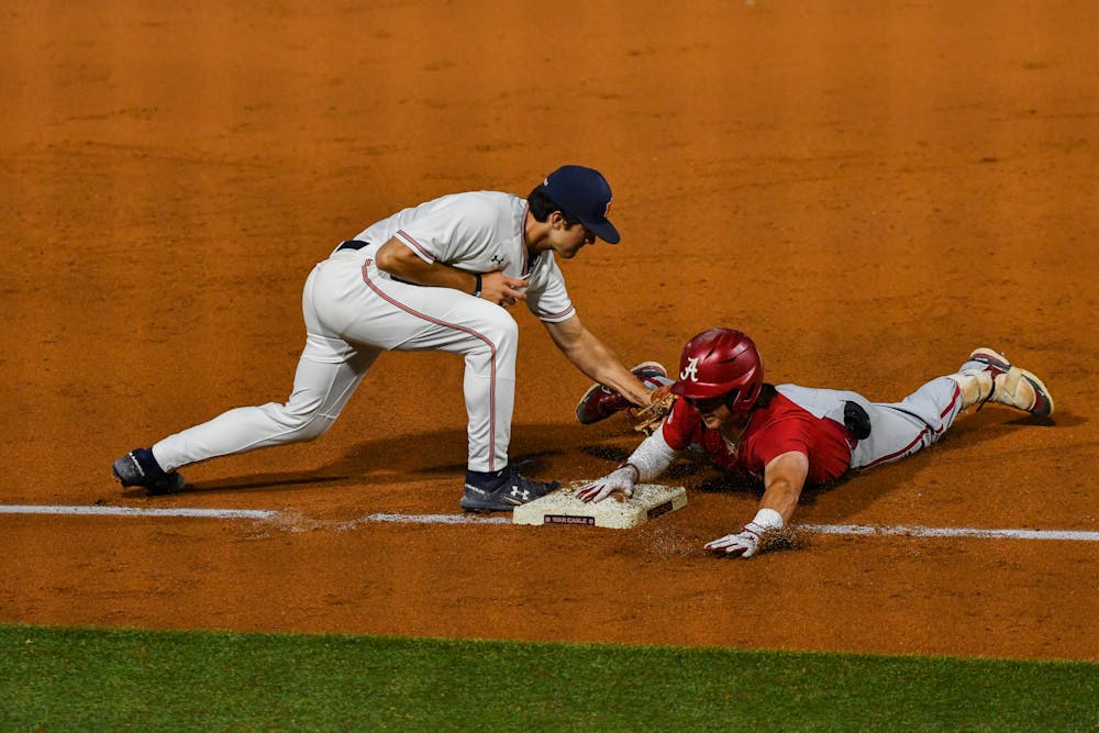 Gavin Miller (#11) tags runner out in a match of Auburn and Alabama at Plainsman Park on Oct. 28, 2022
