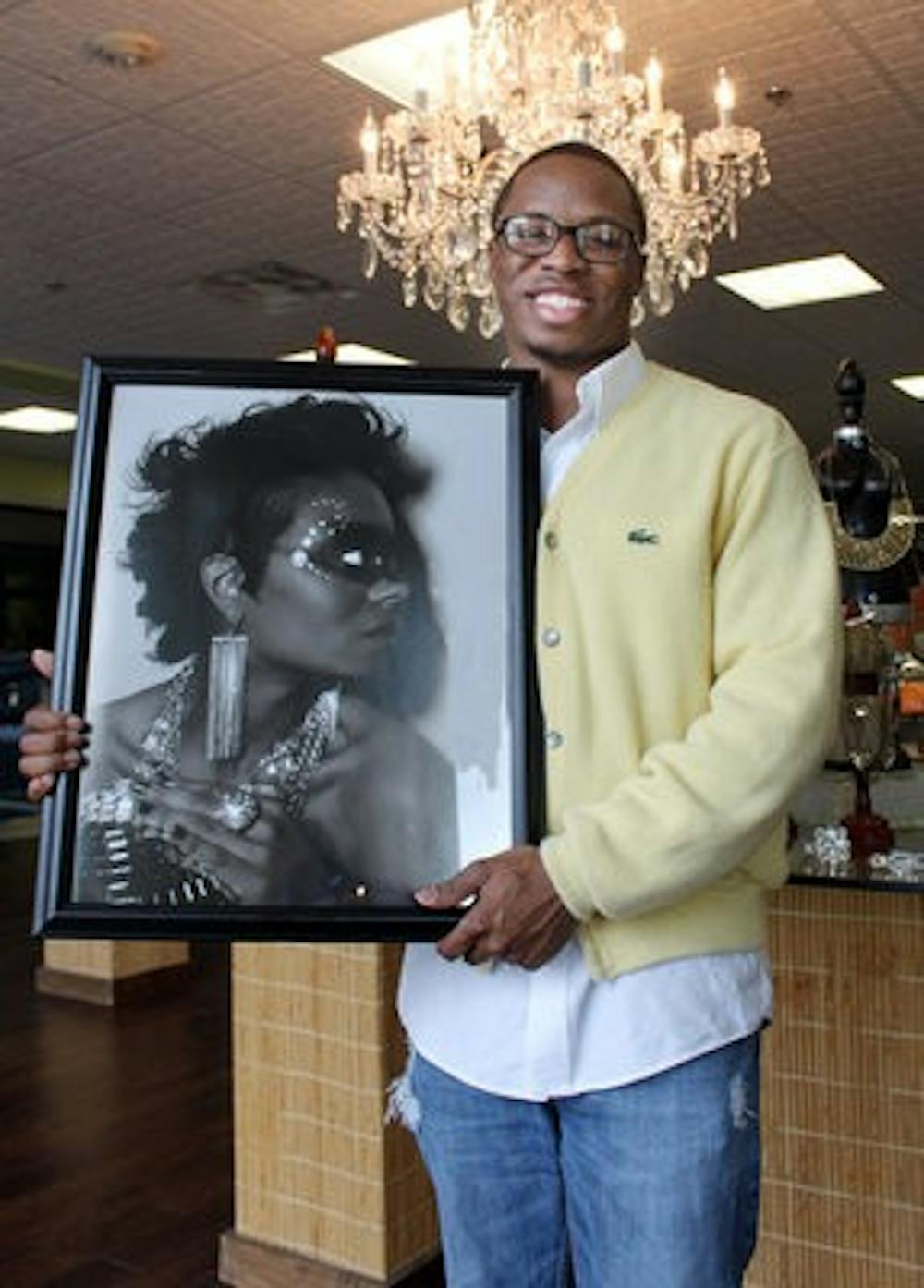 RaChard White stands with his fashion art in Private Gallery. (Emily Adams / Photo Editor)
