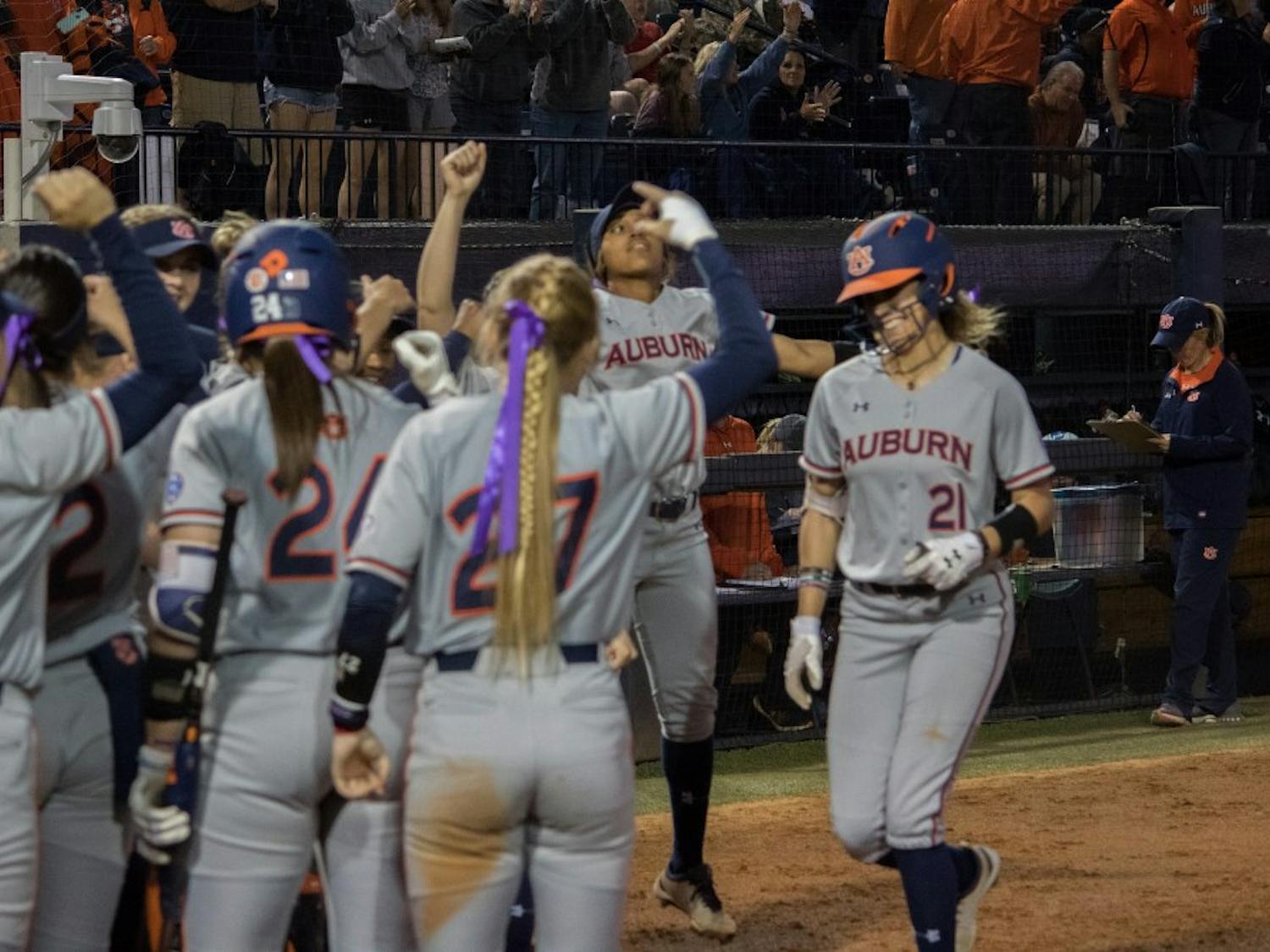 The Auburn Softball team greets Alyssa Rivera (21) at home plate against Arkansas Friday, April 20, 2018, in Auburn, Ala. 