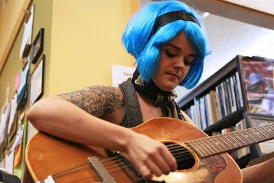 Emily Schott strums a tune on her guitar during Expressions Cafe at The Gnu's Room Friday night. The monthly open-mic event features performances by writers, musicians and artists. (Rebecca Croomes / PHOTO EDITOR)