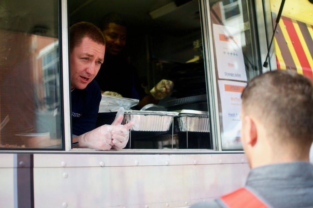 Associate Provost and Senior Vice President for Student Affairs Bobby Woodard serves waffles to students on Wednesday, Aug. 22, 2018 in Auburn, Ala.