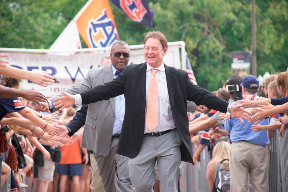<p>Assistant Coach Greg Brown high-fives fans during Tiger Walk on Saturday, Sept. 30, 2017 in Auburn, Ala.</p>