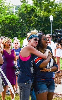 Anna Grafton, senior in environmental science, and Morgan Jackson, senior in English, mourn the loss of former Auburn football player Philip Lutzenkirchen at Toomer's Corner on Sunday, June 29.

Raye May / PHOTO & DESIGN EDITOR
