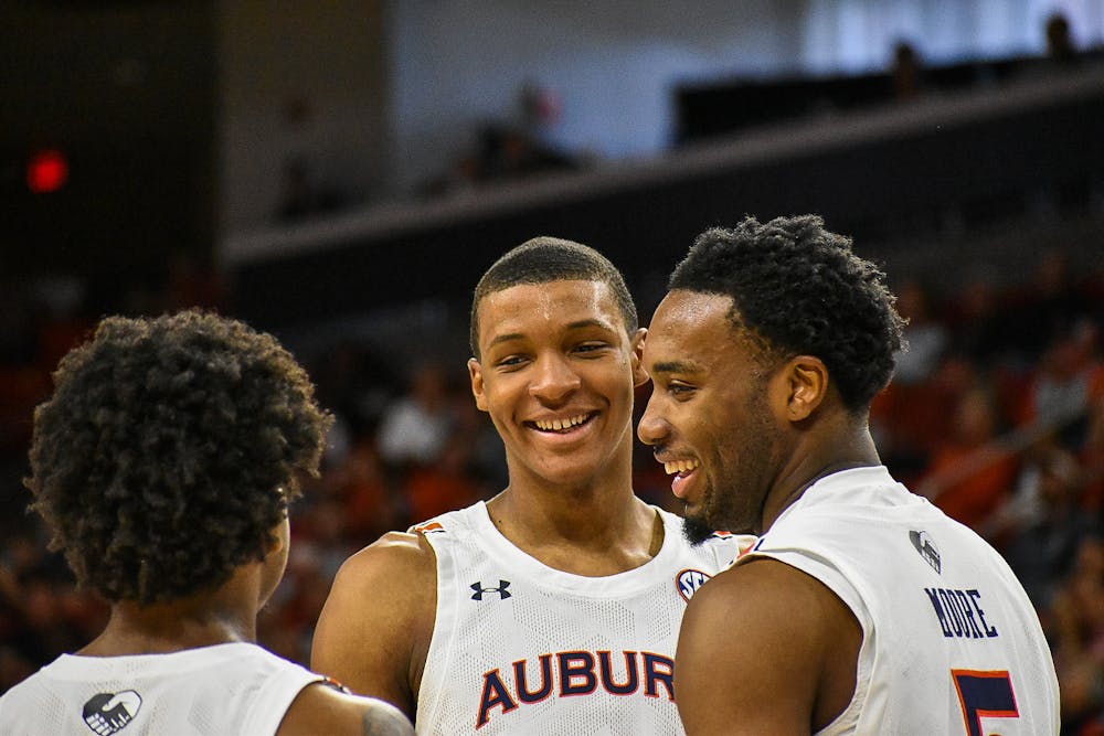 Dec. 4, 2021; Auburn, Alabama; Jabari Smith (10), Chris Moore (5) and Wendell Green Jr. (1) share laughs during a timeout in a match between Auburn and Yale in the Auburn Arena.