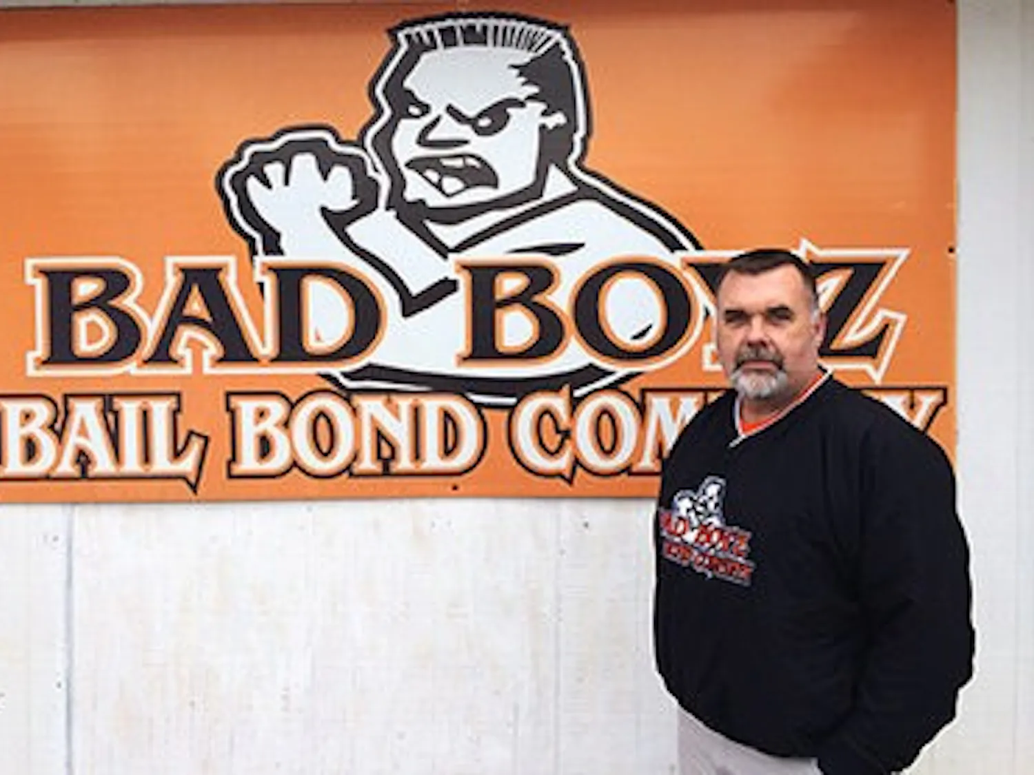 Corey Marmaduke stands in front of his Bad Boyz Bail Bond Company logo