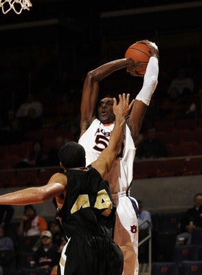 Freshman Willy Kouassi attempts a jump shot over a Vanderbilt defender. Kouassi averaged 1.5 points in 10.2 minutes per game this season. (TODD VAN EMST)