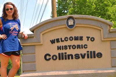 Shaye McCauley, junior in social work, stands in front of her town's sign.