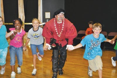 Baron Blackwolf and students run toward the center of the room while playing a Renasissance period game. (Christen Harned / Assistant photo editor)