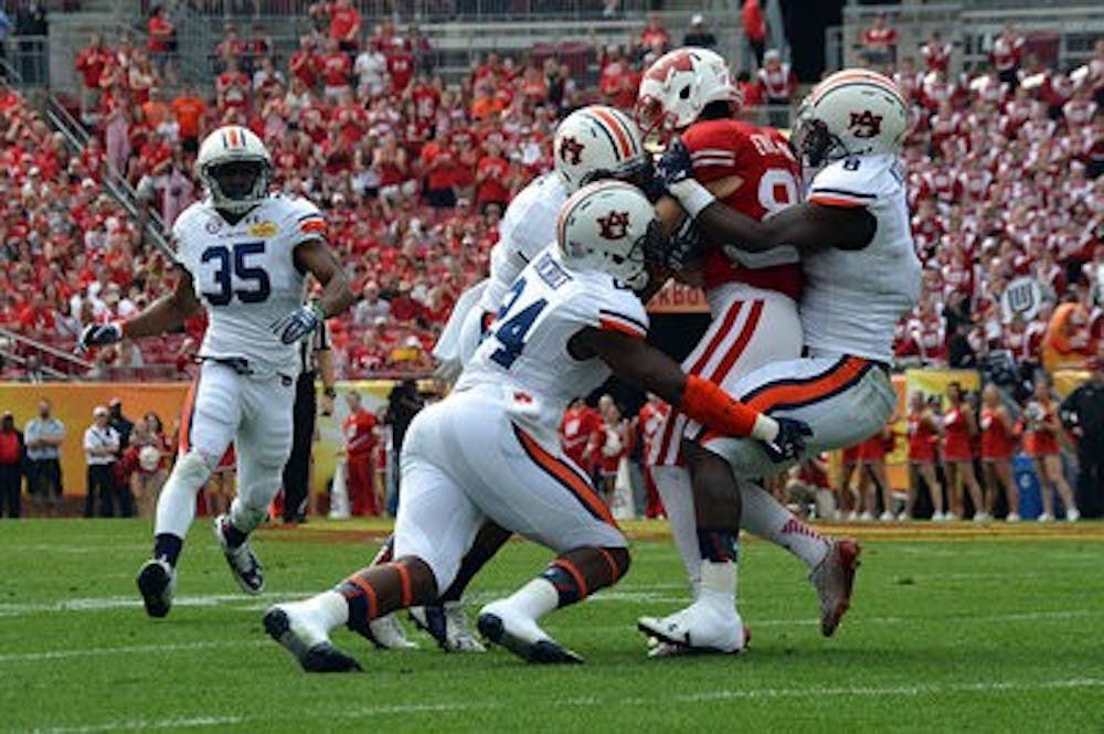 <p>Cameron Artis-Payne is wrapped up by Wisconsin defenders. (Emily Enfinger / Photo Editor)</p>
