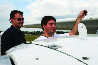 Joe McDonald, right, senior in aviation management, checks the oil of a single-engine propeller plane with instructor Matt Jones. Auburn Aviation offers discounted starter lessons to those interested in earning their wings. (Rebecca Croomes / PHOTO EDITOR)