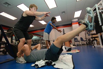 Alex Jenkins, a junior in pre-pharmacy, and Luke Phaff, a junior  in pre-pharmacy do leg throwdowns in PHED 1200, "Boot Camp."        Austin Nelson/Associate Photo Editor