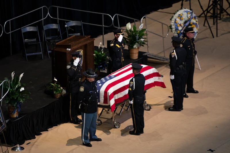 Police Officers drape an American Flag over the casket at the Funeral of Auburn Police Officer William Buechner on Friday, May 24, 2019, in Auburn, Ala.
