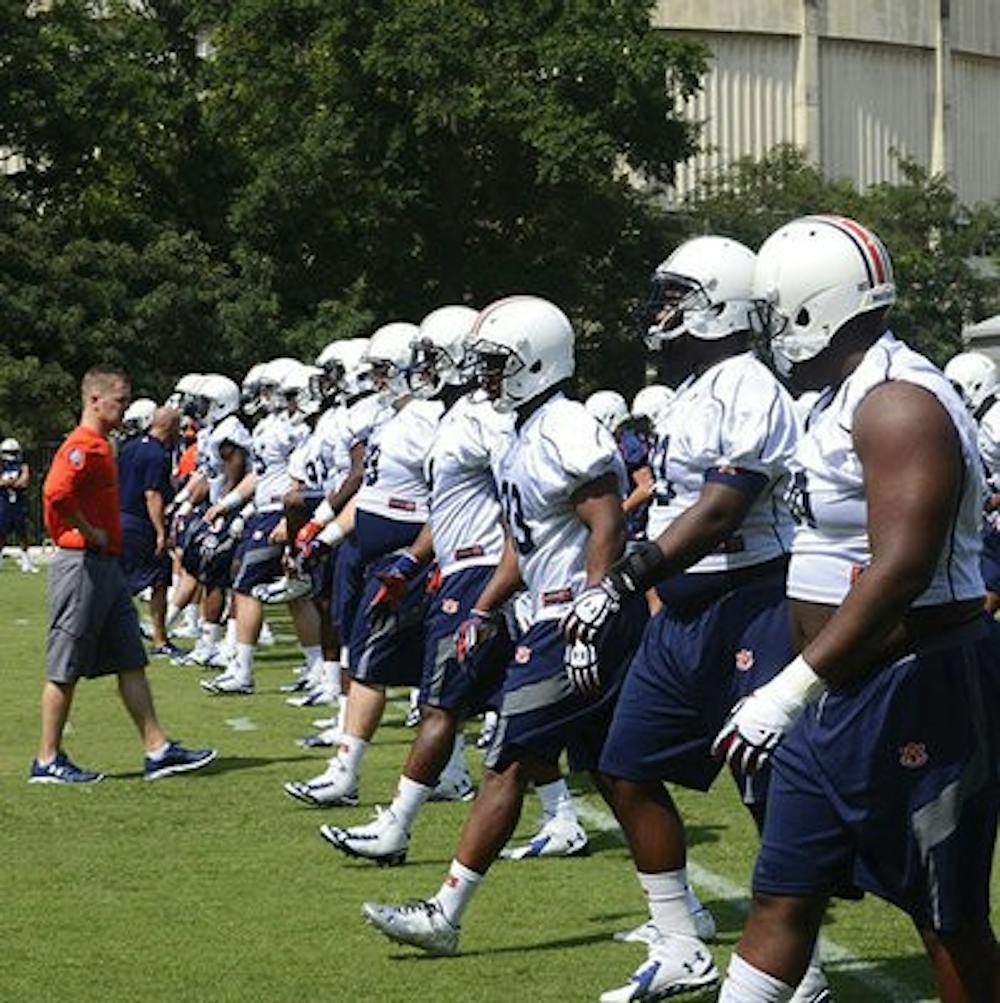 <p>Auburn football players warm up prior to the first practice of fall camp. (Sarah May | Photographer)</p>