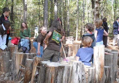 Fifth-grade students from Cary Woods Elementary play on the Nature Playground at the Louise Kreher Forest Ecology Preserve Nov. 9. The playground is designed to provide fun, naturalistic play spaces with logs, tunnels, trees and unique structures, such as a tree house and an "eagle's nest" for kids to explore. (Elaine Busby / Assistant PHOTO EDITOR)