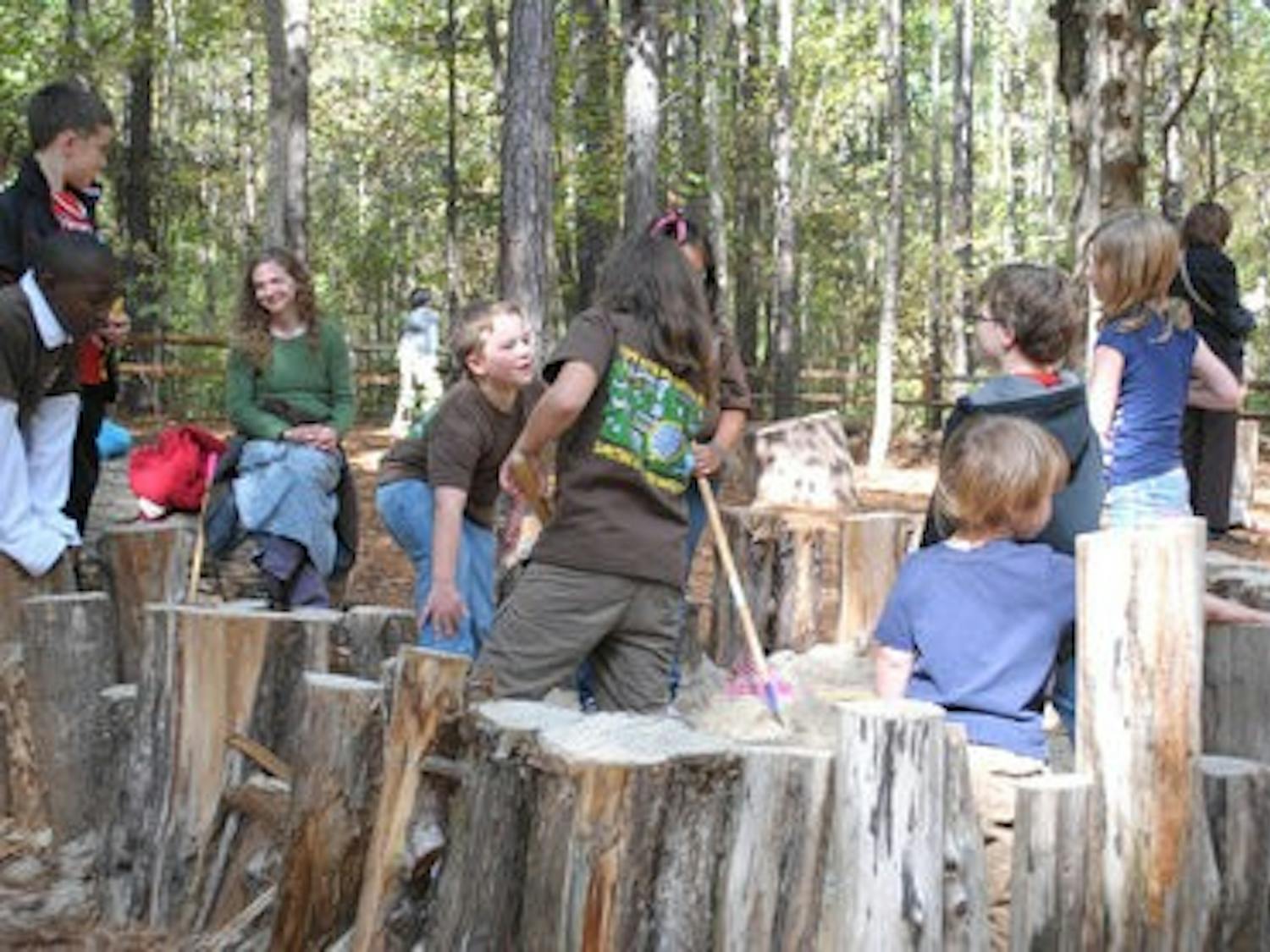 Fifth-grade students from Cary Woods Elementary play on the Nature Playground at the Louise Kreher Forest Ecology Preserve Nov. 9. The playground is designed to provide fun, naturalistic play spaces with logs, tunnels, trees and unique structures, such as a tree house and an "eagle's nest" for kids to explore. (Elaine Busby / Assistant PHOTO EDITOR)