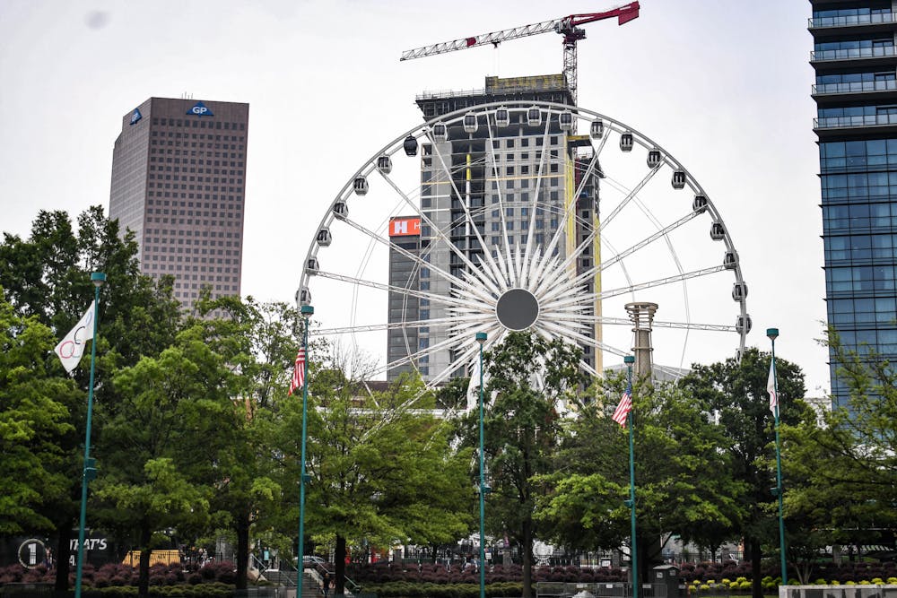 Centennial Park's ferris wheel is eclipsed by foggy sky scrapers on the morning of July 21, 2022.