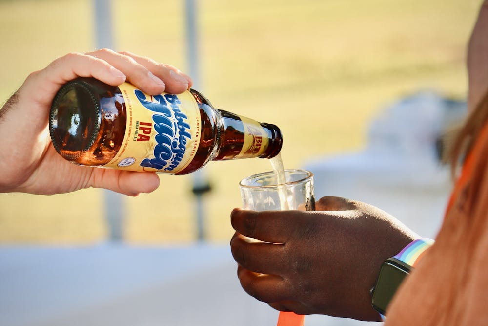 <p>Vendor pours Oktoberfest attendee a beer at an event. Photo by Hanjiaxi Qin, former photo editor.</p>