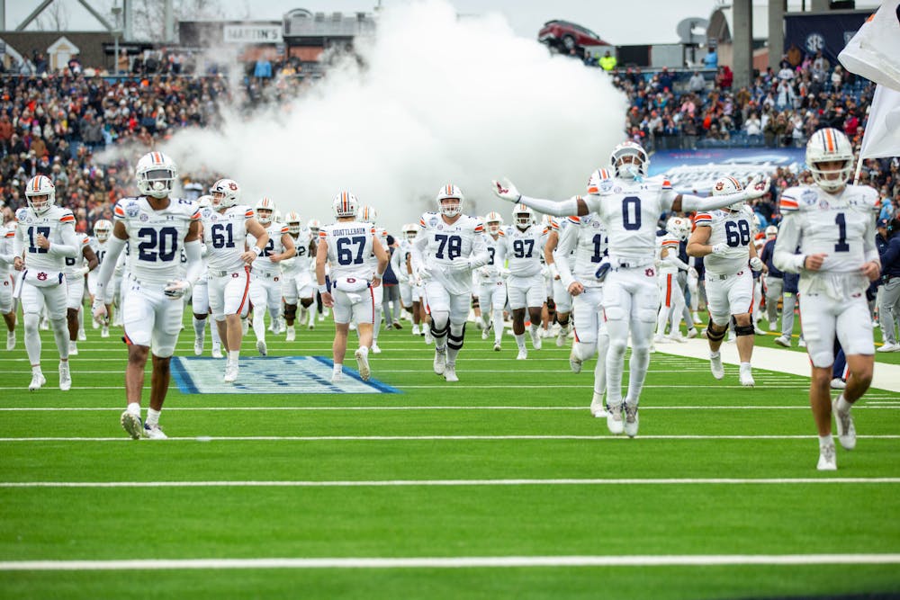<p>The Auburn football team runs out of the tunnel at the TransPerfect Music City Bowl in Nashville on Dec. 30.</p>