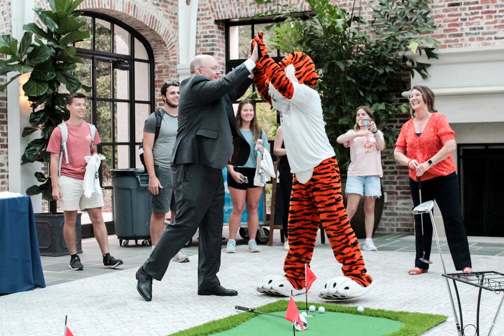 <p>Aubie the Tiger celebrating with Christopher Roberts and Tracy Roberts after putting a hole-in-one at Pizza &amp; Popsicles with the President on Sept. 13, 2023.</p>