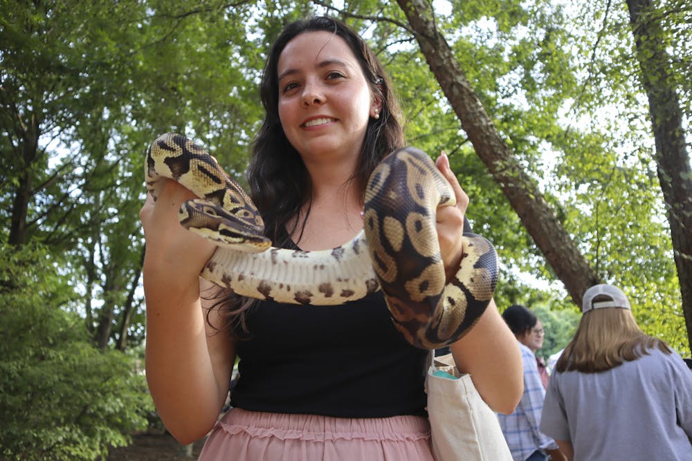 Auburn student Jennifer Hamilton holds a snake at the Auburn University Sustainability Picnic at the Donald E. Davis Arboretum on August 27, 2025. 