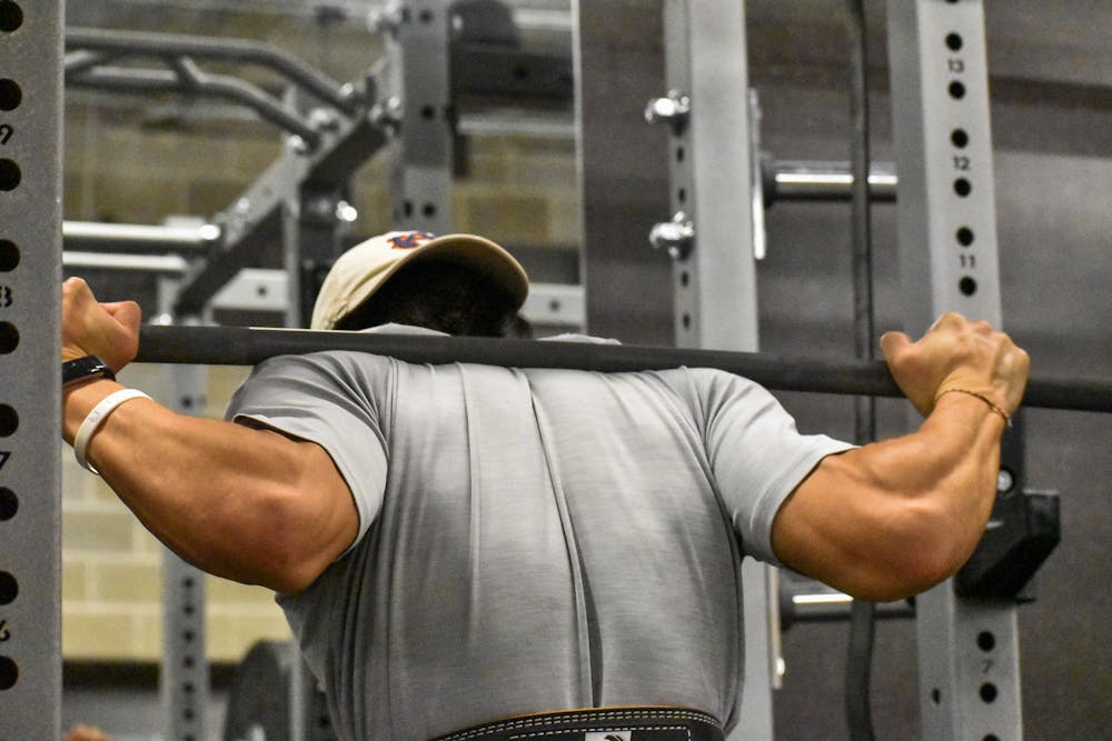 <p>An Auburn student prepares to lift a bar off of a power rack in the Auburn University Recreation and Wellness Center.</p>