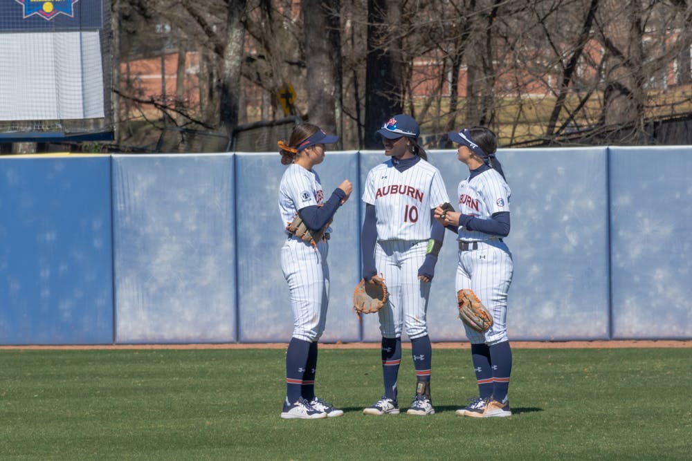 <p>Feb. 13, 2022; Auburn, Ala; Carlee McCondichie (left), Makayla Packer (center) and Lindsey Garcia (right) talk in the outfield during a break in the action against UMass Lowell in the Tiger Invitational.</p>