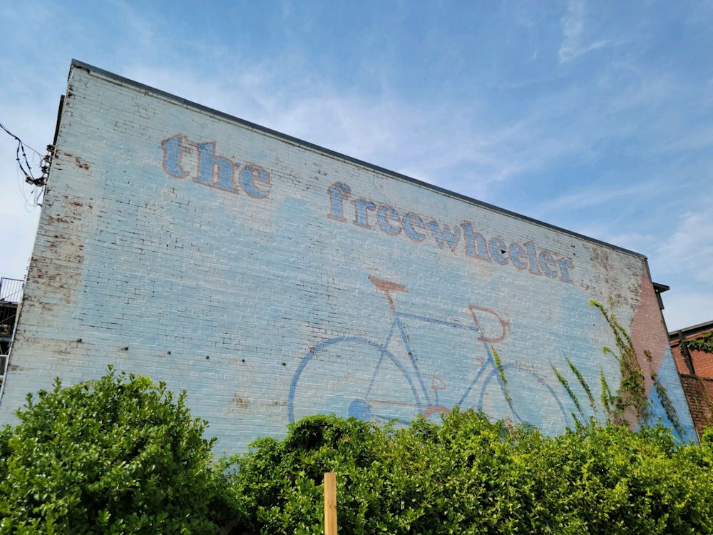 <p>The Freewheeler, a mural on the side of an old bicycle shop on College Street, is one of few pieces of public art in downtown Auburn.</p>