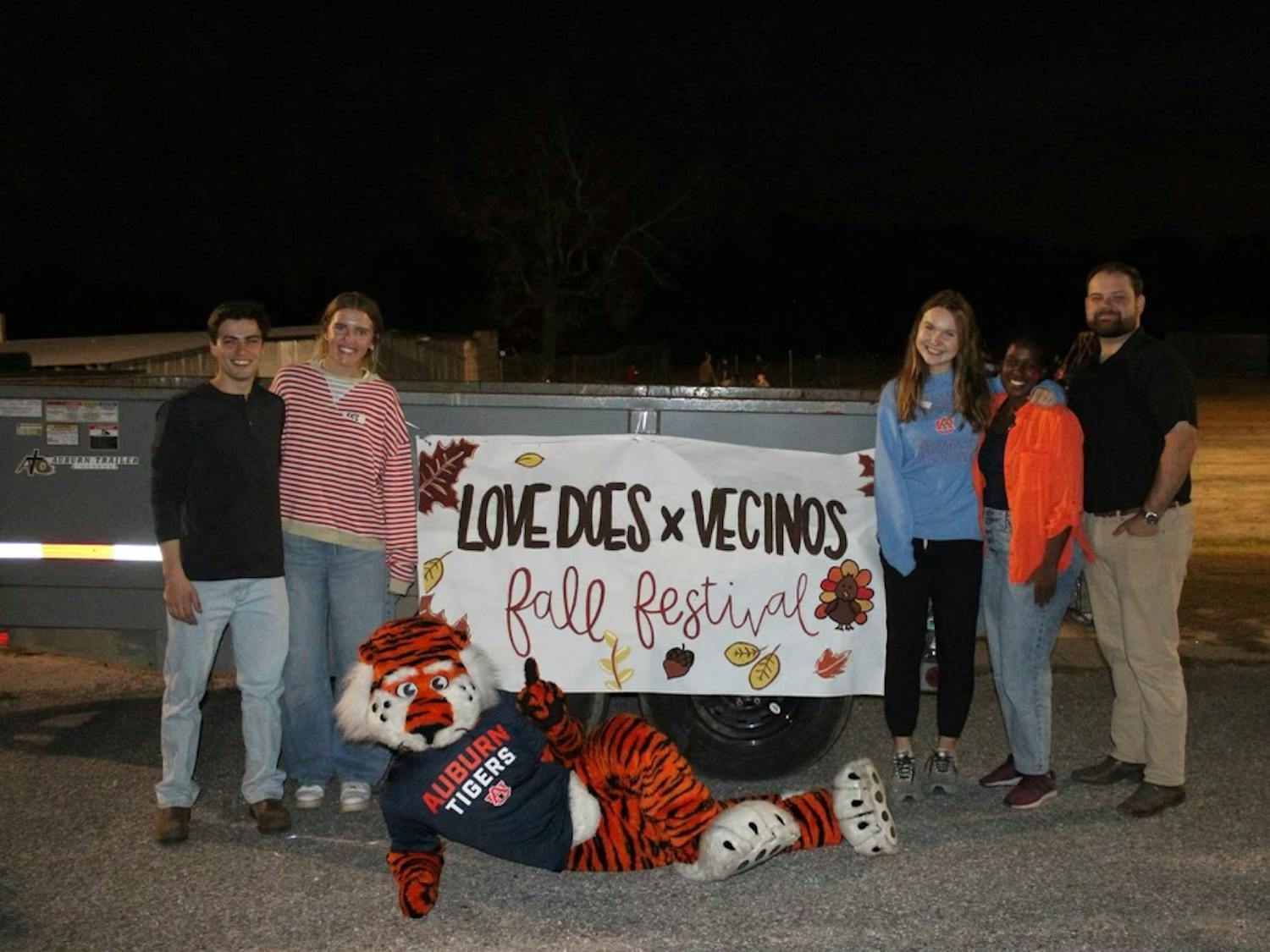 Love Does in Action members pose in front of a sign for the fall festival hosted with Vecinos Ministry. Contributed by Love Does in Action.
