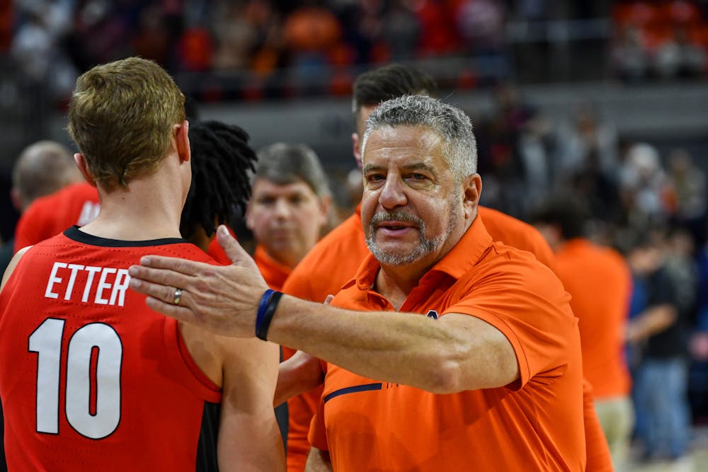 <p>Bruce Pearl pats a Georgia player on the back after an Auburn win at Neville Arena on February 1st 2023</p>