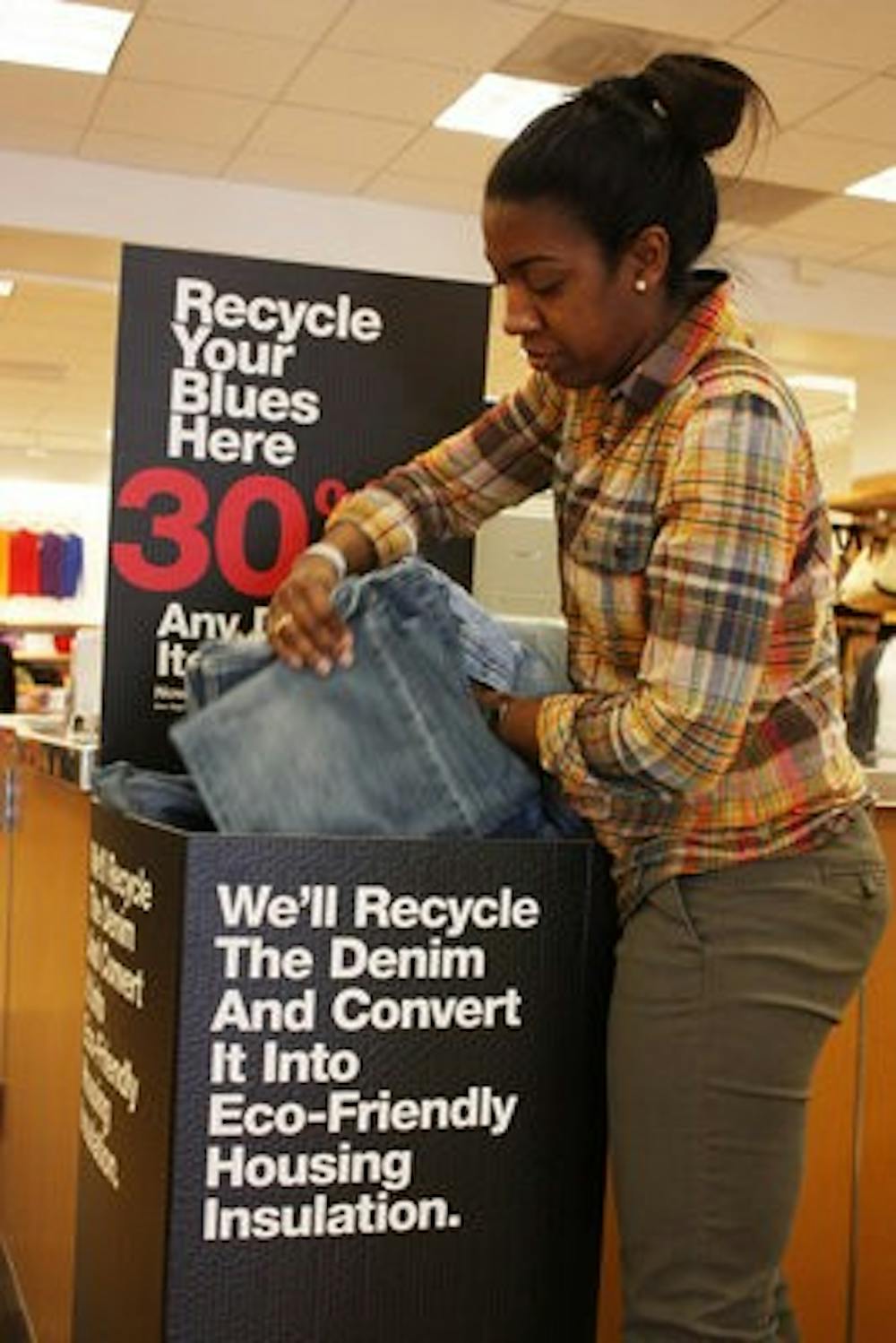 Antoinette Pulliam adjusts the pile of jeans that have been donated to 'Recycle Your Blues.'