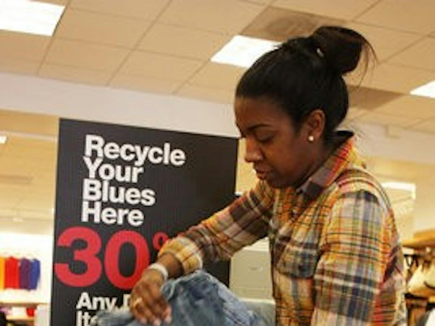 Antoinette Pulliam adjusts the pile of jeans that have been donated to 'Recycle Your Blues.'
