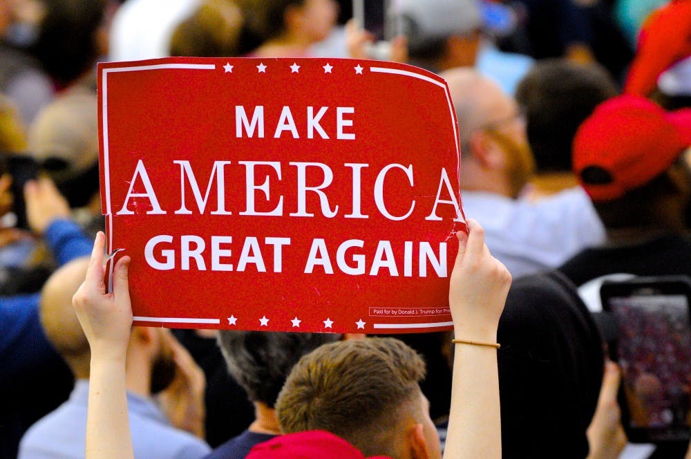 <p>A Trump supporter holds a rally sign at a Trump event in Mobile, Alabama, in December 2016. Voters in Auburn head to the polls Monday in a primary marked by who will be most supportive of Trump's agenda.</p>