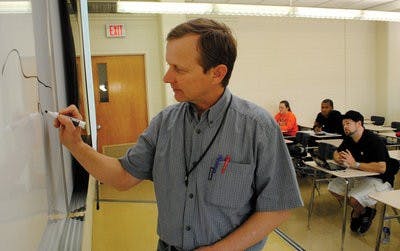 Wheeler Foshee, associate professor of horticulture, demonstrates on the whiteboard how to plant green beans. Wheeler teaches Sustainable Vegetable Crop Production. (Maria Iampietro / Associate Photo Editor)