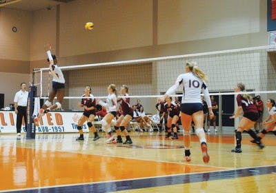 Freshman setter Chelsea Wintzinger watches from the backfield as sophomore Sarah Bullock (left) and senior Lauren Mellor (right) go up for a block. (Elaine Busby/ ASSOCIATE Photo Editor)