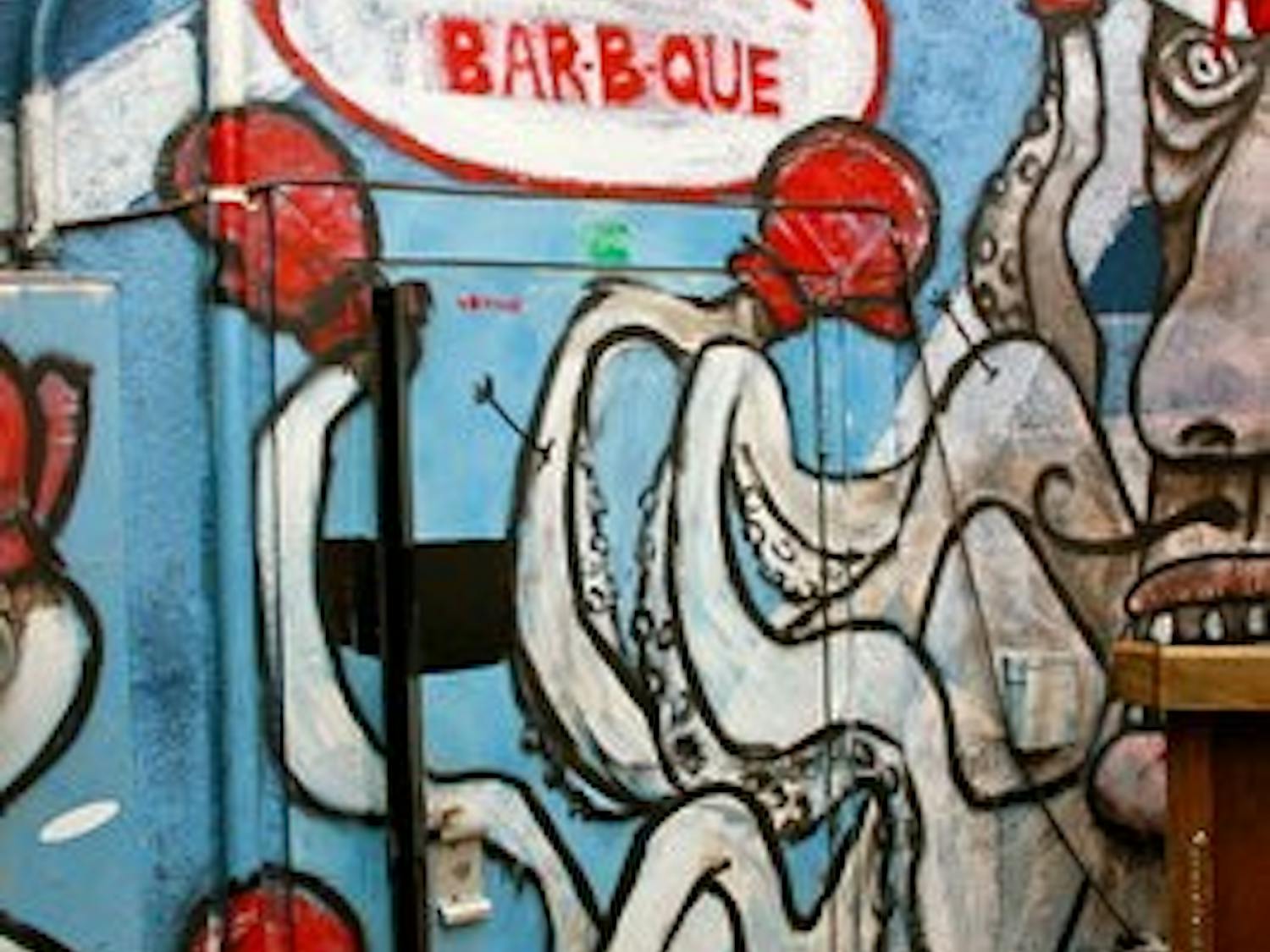 The murals Christian Hamrick painted at Moe's Bar-B-Que are funky, one-of-a-kind anecdotes that cover the brick walls on the inside of the restaurant and outside on the back patio. (Courtesy of Chelsea Wooten)
