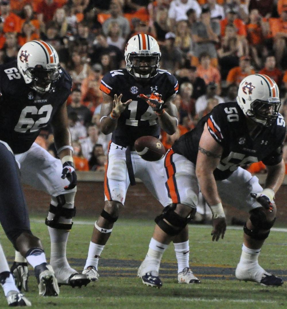 Center Reese Dismukes snaps the ball to Quarterback Nick Marshall. (File photo)