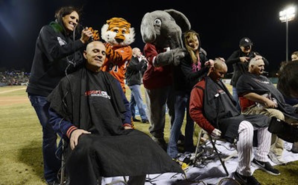 Auburn coach John Pawlowski and Alabama coach Mitch Gaspard have their heads shaved Tuesday March 5, before the game begins. (Courtesy of Todd Van Emst / AUBURN ATHLETICS)