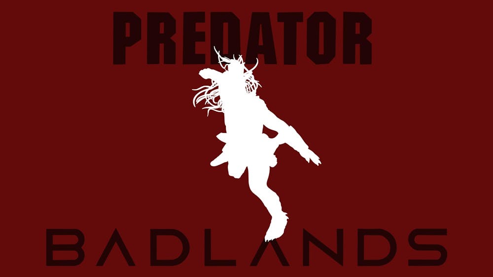 <p>A white silhouette of Dek posed dynamically overlays a dark red background, with the words "PREDATOR" and "BADLANDS" prominently displayed.</p>