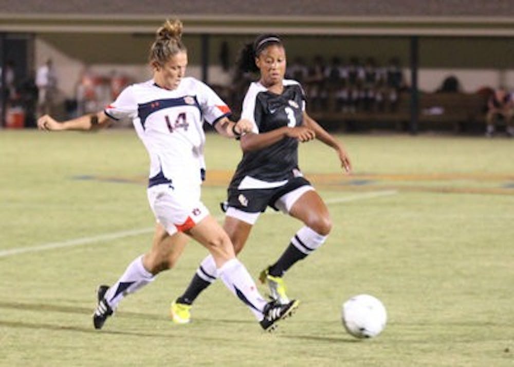Junior defender Heather Havron (left) battles for the ball with junior midfielder Casey Short (right) during Friday night's game against No. 5 Florida State. Auburn won 3-2. (Emily Adams / PHOTO EDITOR)