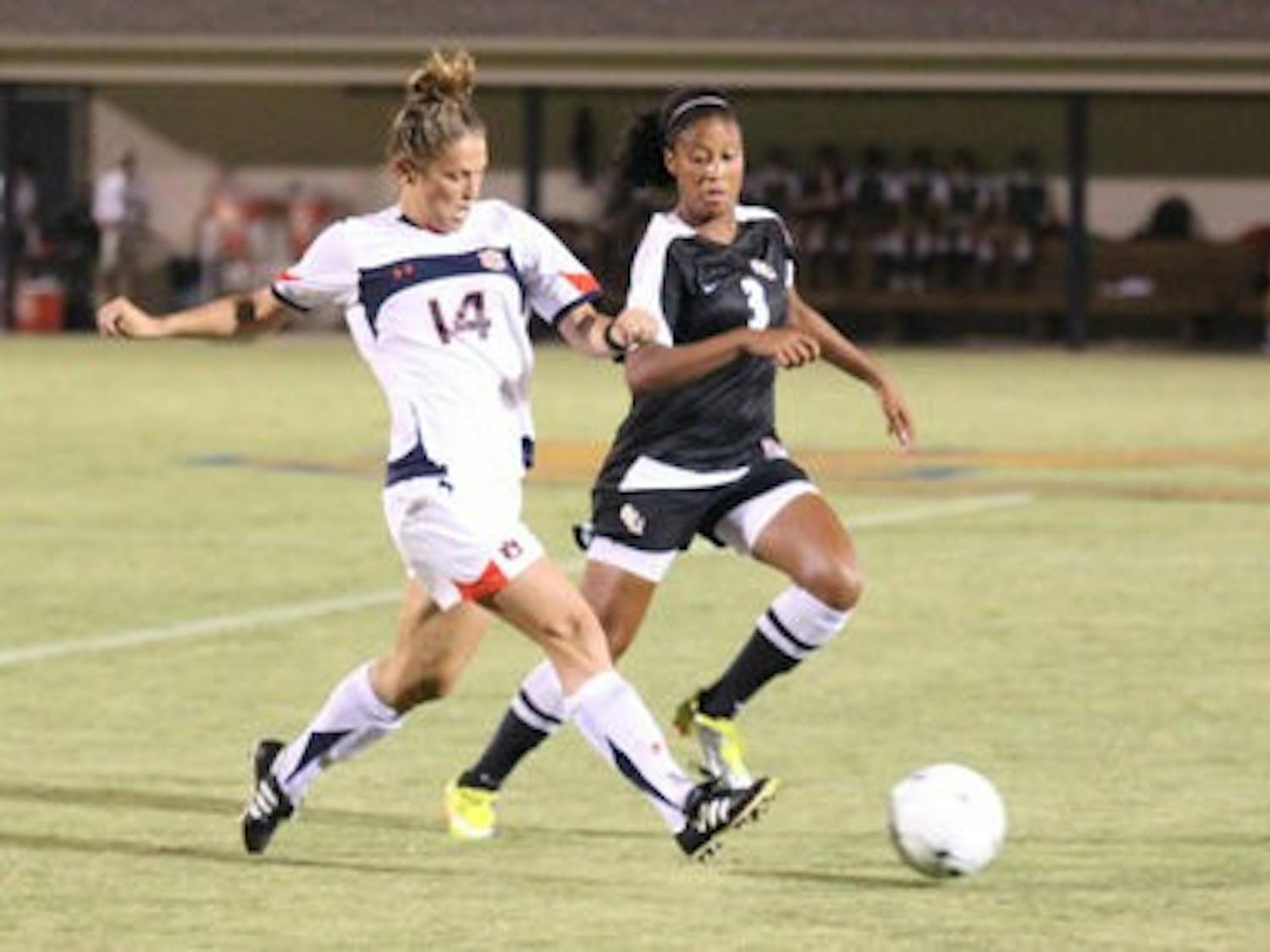 Junior defender Heather Havron (left) battles for the ball with junior midfielder Casey Short (right) during Friday night's game against No. 5 Florida State. Auburn won 3-2. (Emily Adams / PHOTO EDITOR)