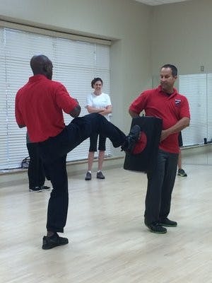 Lt. Jonathan Ley a holds practice pad while officer Antonio Fannin demonstrates technique.